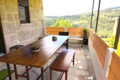 two wooden tables and chairs on a balcony with a view at Casa A mi Vera in Covelo