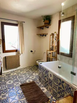 a bathroom with a tub and a toilet and a window at Farm house in Ribeira Sacra in O Carballo