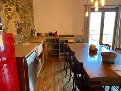 a kitchen with a wooden table and a wooden floor at Farm house in Ribeira Sacra in O Carballo