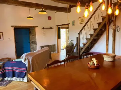 a living room with a table and a staircase at Farm house in Ribeira Sacra in O Carballo