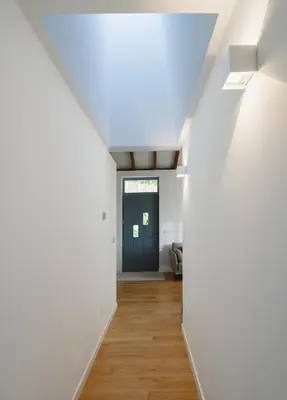 a hallway with white walls and a blue door at O Souto da Aldea Ribeira Sacra Parada de Sil in Parada del Sil