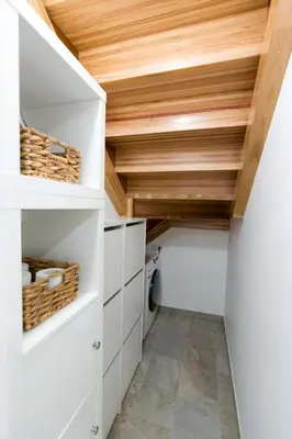 a laundry room with white cabinets and a wooden ceiling at Apartamento con jardín en San Sadurniño in Santa María La Mayor del Rosario