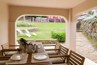 a table and chairs on a patio with a view of a yard at Apartamento con jardín en San Sadurniño in Santa María La Mayor del Rosario