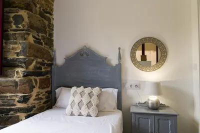 a bedroom with a bed and a mirror on the wall at Apartamento con jardín en San Sadurniño in Santa María La Mayor del Rosario