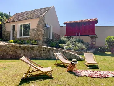 two lawn chairs and a woman sitting in a yard at seixurra 31 in A Coruña