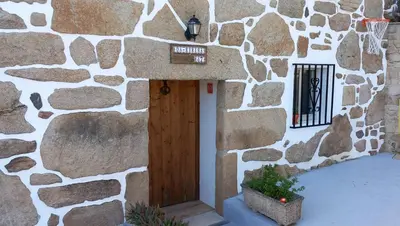 a stone building with a wooden door and a window at Casa da Eiriña in Amés
