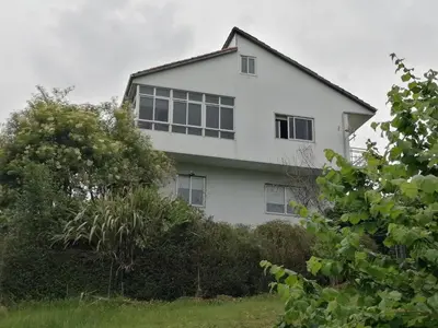a white house with windows on a hill at A CASA DOS AVÓS in Celanova