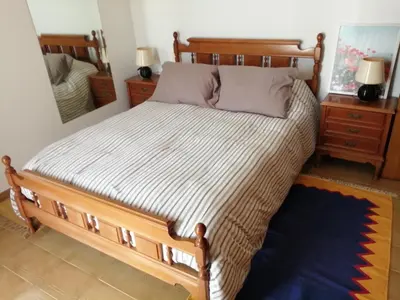 a bedroom with a large bed with a mirror at A CASA DOS AVÓS in Celanova