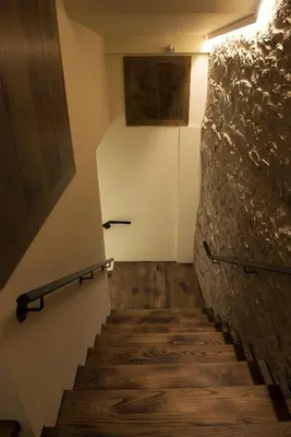a staircase with wooden floors and a stone wall at PENSION SOBRADO in Porta