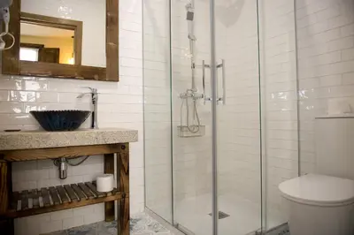 a bathroom with a glass shower and a toilet at PENSION SOBRADO in Porta