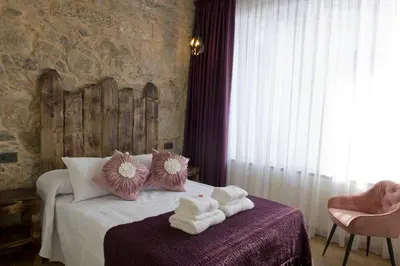 a bedroom with a bed with towels on it at PENSION SOBRADO in Porta