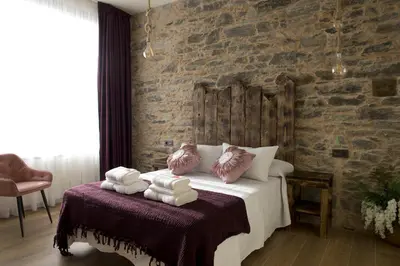 a bedroom with a bed with towels on it at PENSION SOBRADO in Porta