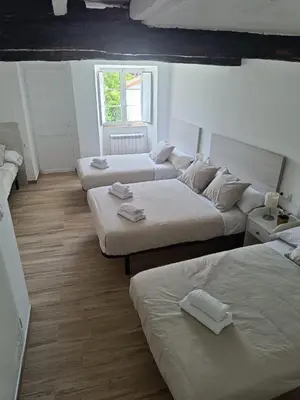 a room with three beds and a window at CASA A CALLE in O Pino