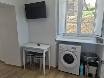 a laundry room with a washing machine and a table at CASA A CALLE in O Pino
