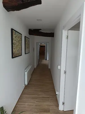 a long hallway with white walls and wood floors at CASA A CALLE in O Pino