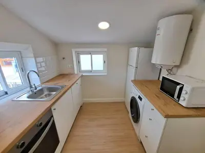 a small kitchen with a sink and a microwave at Atico Porta de Santiago - Junto Catedral - VUT-LU-02906 in Lugo