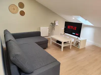 a living room with a couch and a tv at Atico Porta de Santiago - Junto Catedral - VUT-LU-02906 in Lugo