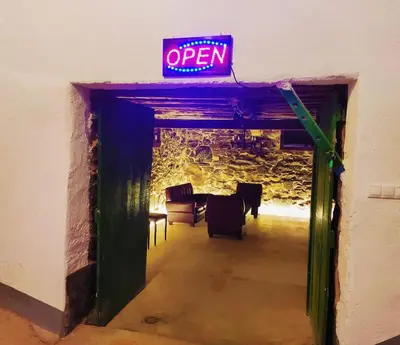 a neon open sign in a room with a table at Casa de Ribeira Sacra in Pantón