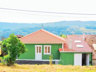 a green house with an orange roof on a hill at Casa de Ribeira Sacra in Pantón