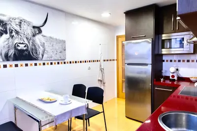 a kitchen with a table and a cow on the wall at Muralla & Views by Lugo Collection in Lugo