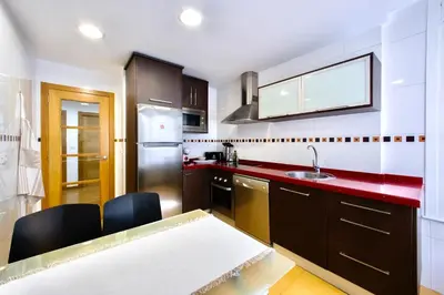 a kitchen with a sink and a red counter top at Muralla & Views by Lugo Collection in Lugo