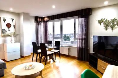 a living room with a table and chairs and a television at Muralla & Views by Lugo Collection in Lugo