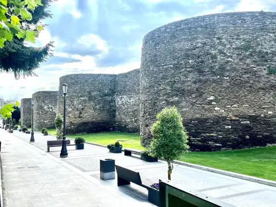 a stone wall with benches in front of a building at Muralla & Views by Lugo Collection in Lugo