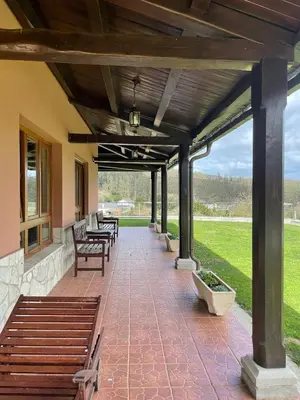 a patio with benches and tables on a building at Cabo de Veiga in Trabada