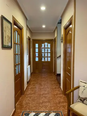 a hallway with wooden doors and a tile floor at Cabo de Veiga in Trabada