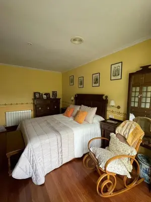 a bedroom with a large bed and two chairs at Cabo de Veiga in Trabada