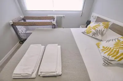 a room with a bed with two towels on it at La Casa de Julia Apartamento nuevo y céntrico in Santiago de Compostela