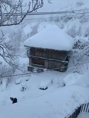 a building covered in snow in a yard at Habitaciones Frade in O Cebreiro