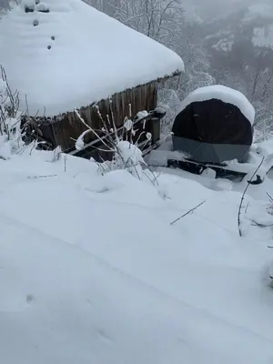 a house covered in snow next to a fence at Habitaciones Frade in O Cebreiro