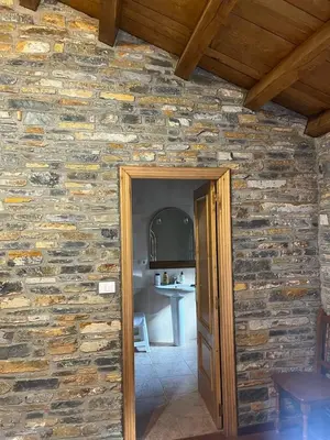 a room with a stone wall with a doorway at Habitaciones Frade in O Cebreiro