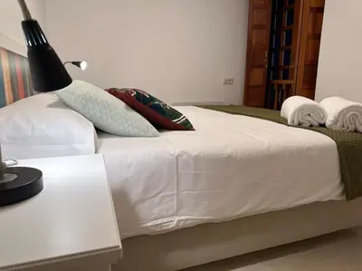 a bedroom with a white bed with pillows on it at Porta da Vila by Oktheway in Puentedeume