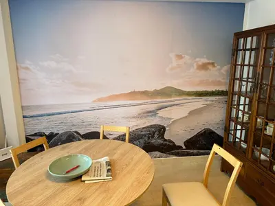 a dining room table with a painting of the beach at Porta da Vila by Oktheway in Puentedeume