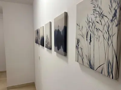 a row of paintings hanging on a wall at Porta da Vila by Oktheway in Puentedeume