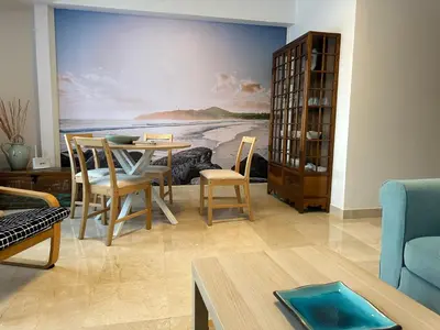 a living room with a painting of the ocean at Porta da Vila by Oktheway in Puentedeume