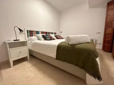 a bedroom with a bed and a lamp on a night stand at Porta da Vila by Oktheway in Puentedeume