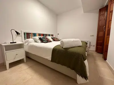 a bedroom with a bed and a lamp on a night stand at Porta da Vila by Oktheway in Puentedeume