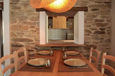 a wooden table with chairs and a dining room at Casa Fente in Taboada