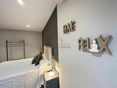 a bedroom with a bed and a lamp on a table at A Morada das Mimosas in Ourense