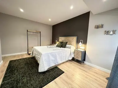 a bedroom with a bed with a white comforter at A Morada das Mimosas in Ourense