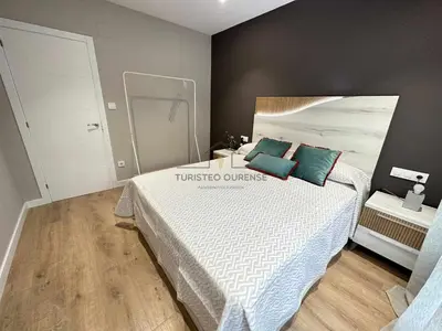 a bedroom with a white bed with blue pillows at A Morada das Mimosas in Ourense