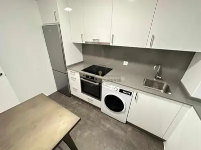 a small kitchen with a stove and a microwave at A Morada das Mimosas in Ourense
