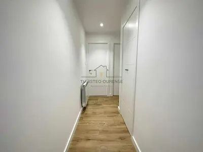 a hallway with white walls and a wooden floor at A Morada das Mimosas in Ourense