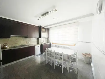 a kitchen with a white table and chairs in it at A DE NENO in Melide
