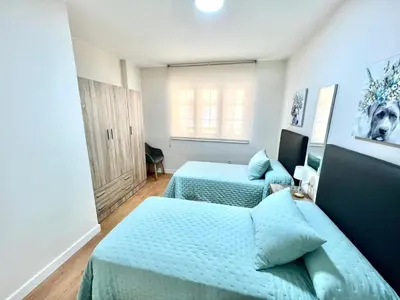 a bedroom with two beds with blue sheets at EL NORTE in Viveiro