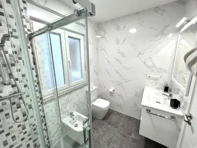 a bathroom with a shower and a toilet and a sink at EL NORTE in Viveiro