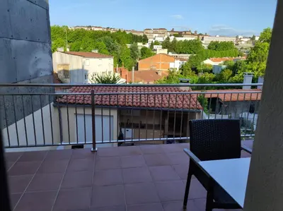 a balcony with a table and a view of a city at Apartamento Salvadas in Santiago de Compostela